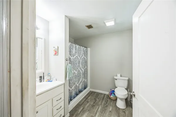 a bathroom with a toilet sink a shower and vanity