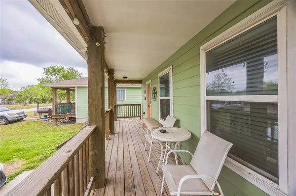 a view of a patio with a dining table and chairs with wooden floor