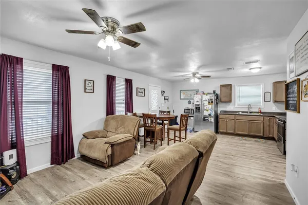 a living room with furniture kitchen view and a window