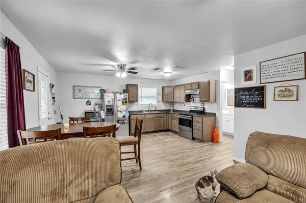 a living room with furniture kitchen view and a window