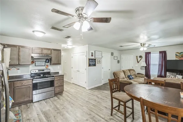 a kitchen with stainless steel appliances granite countertop a sink a stove and a refrigerator
