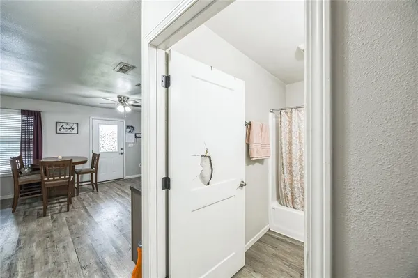 a view of a hallway with furniture and wooden floor