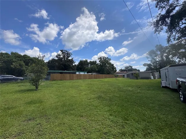 a view of a field of grass and trees