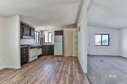 3727 Swallow Avenue Ridgecrest, CA 93555 - Photo 7 of 25 a kitchen with granite countertop a refrigerator and a stove