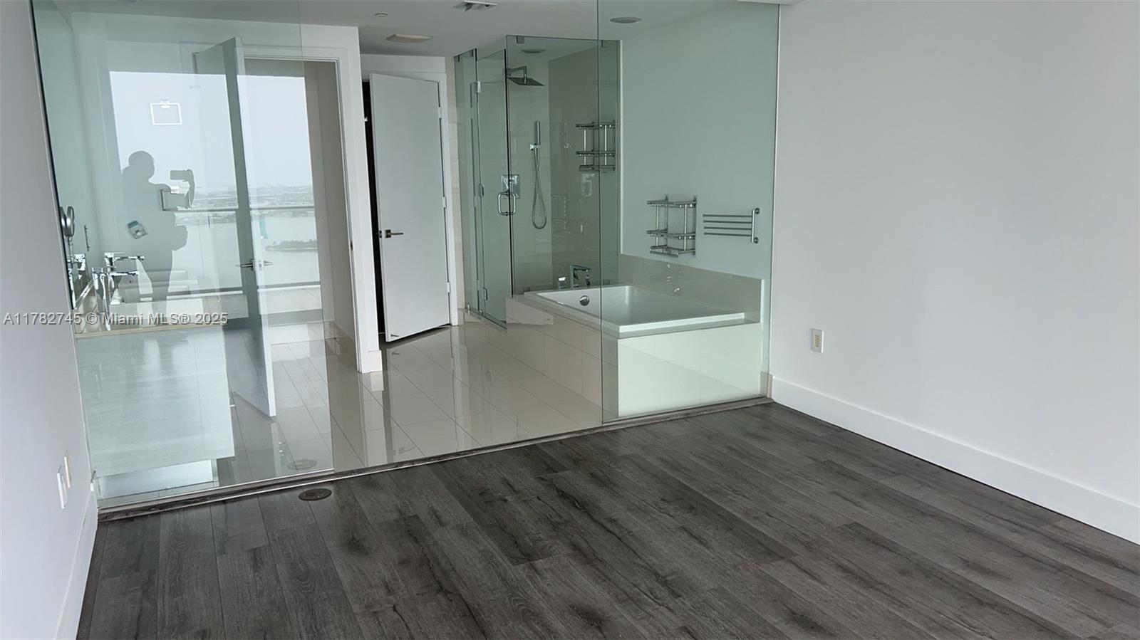 Edgewater Miami, FL 33137 - Photo 5 of 10 a view of an empty room with wooden floor and a bathroom