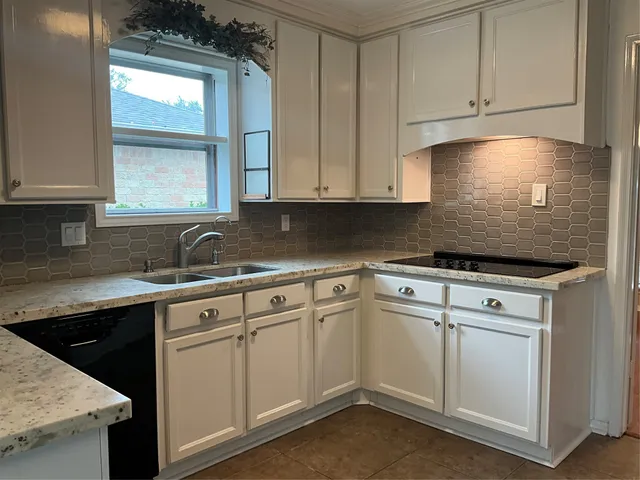 a kitchen with white cabinets appliances and a sink