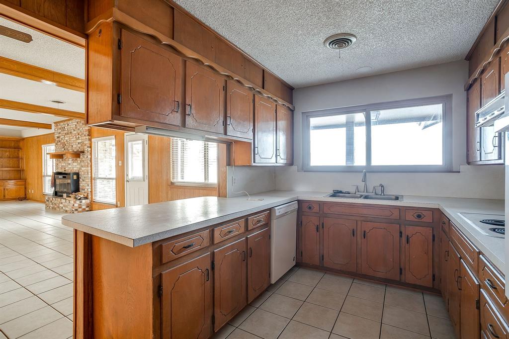 938 County Road 3341 Paradise, TX 76073 - Photo 31 of 40 a kitchen with a sink stove and cabinets