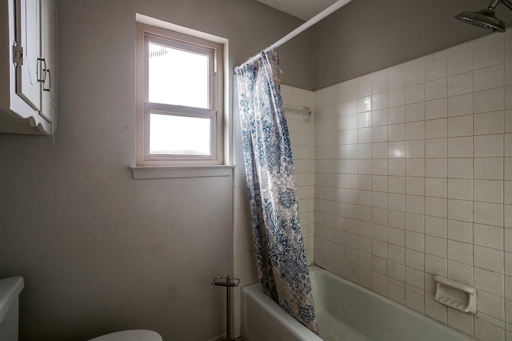 938 County Road 3341 Paradise, TX 76073 - Photo 36 of 40 a bathroom with a shower curtain and window