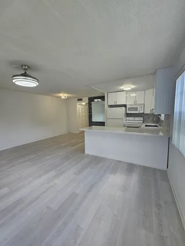 a view of a kitchen with a sink and a refrigerator