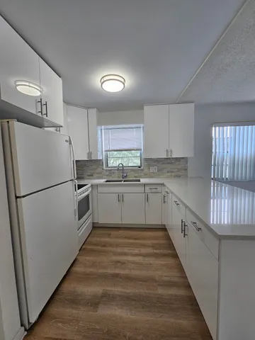 a kitchen with cabinets appliances a sink and a stove