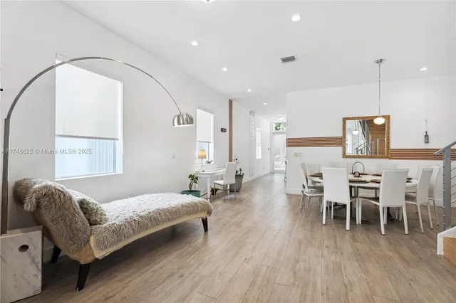 a spacious bedroom with a bed chairs and wooden floor