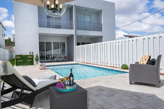 a view of a patio with couches table and chairs and potted plants