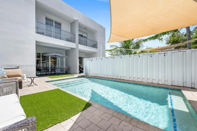 a view of a house with backyard and sitting area