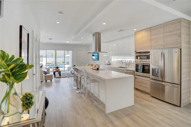 a kitchen with counter top space a sink appliances and living room