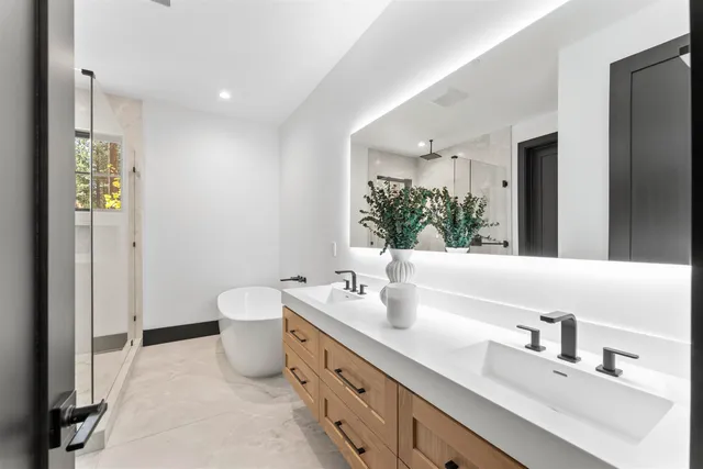 a bathroom with a double vanity sink mirror and toilet