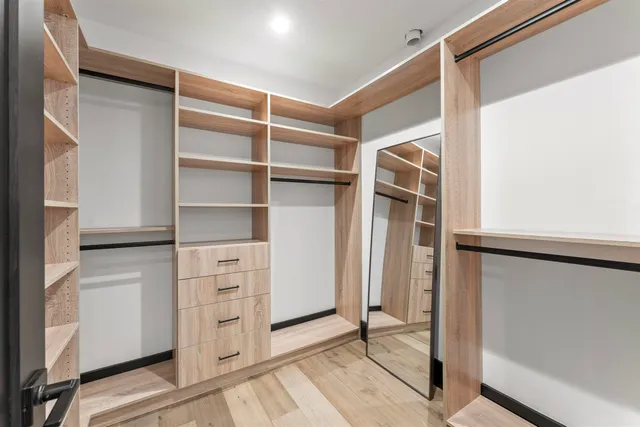 a view of walk in closet with empty racks