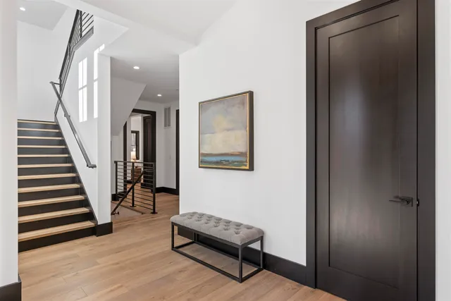 a view of a hallway with wooden floor and stairs