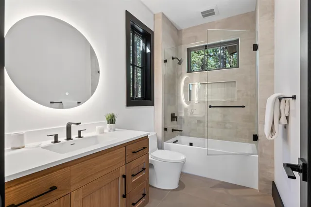 a bathroom with a bathtub shower sink and mirror