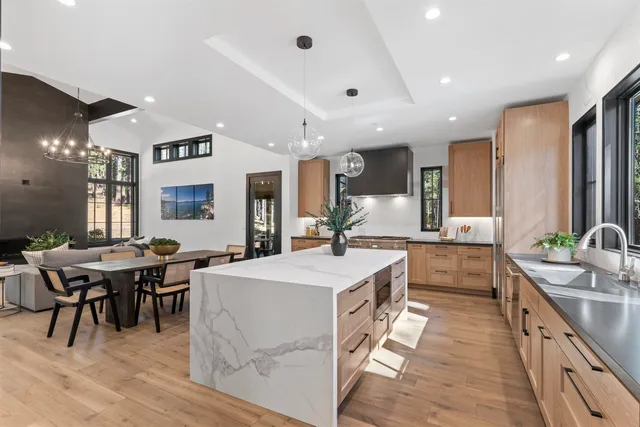 a large kitchen with kitchen island a sink table and chairs