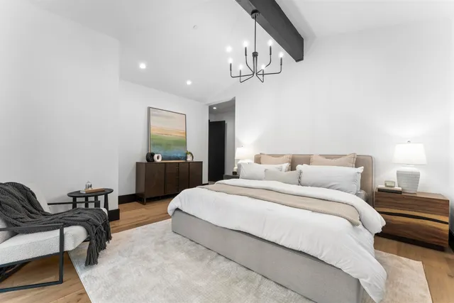 a spacious bedroom with a bed a table and chair