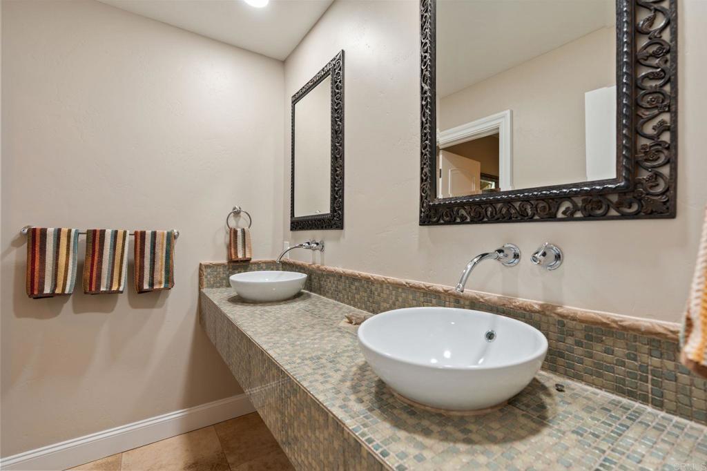 10845 Mystery Mountain Road Valley Center, CA 92082 - Photo 24 of 72 a bathroom with a granite countertop sink and a mirror