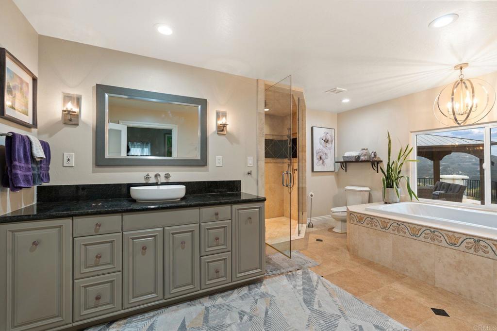 10845 Mystery Mountain Road Valley Center, CA 92082 - Photo 31 of 72 a spacious bathroom with a granite countertop sink mirror and bathtub