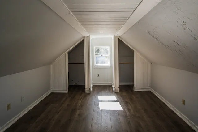 a view of empty room with wooden floor and window