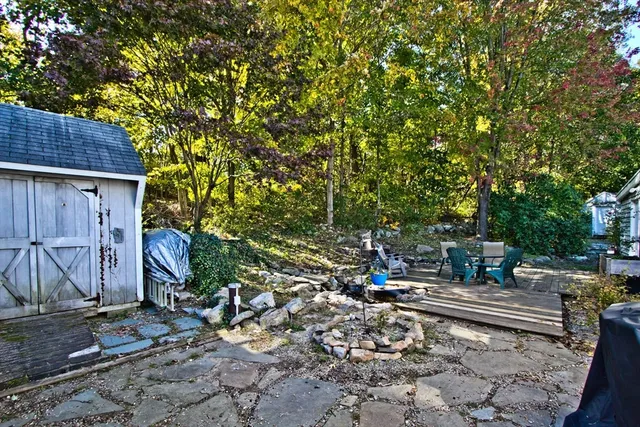 a backyard of a house with barbeque oven table and chairs