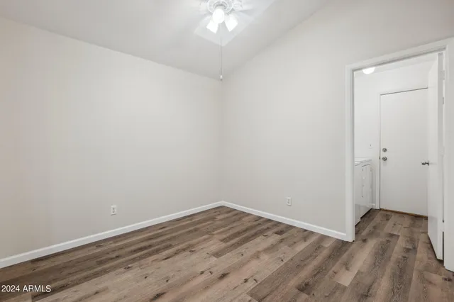 a view of a room with wooden floor and a ceiling fan