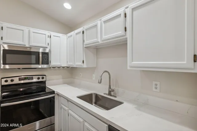 a kitchen with stainless steel appliances granite countertop a sink and a stove