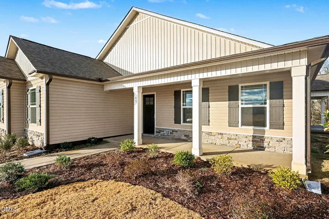 a large kitchen with stainless steel appliances granite countertop a stove a sink dishwasher a refrigerator and white cabinets with wooden floor