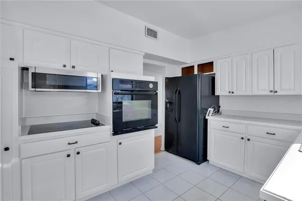 a kitchen with white cabinets and refrigerator
