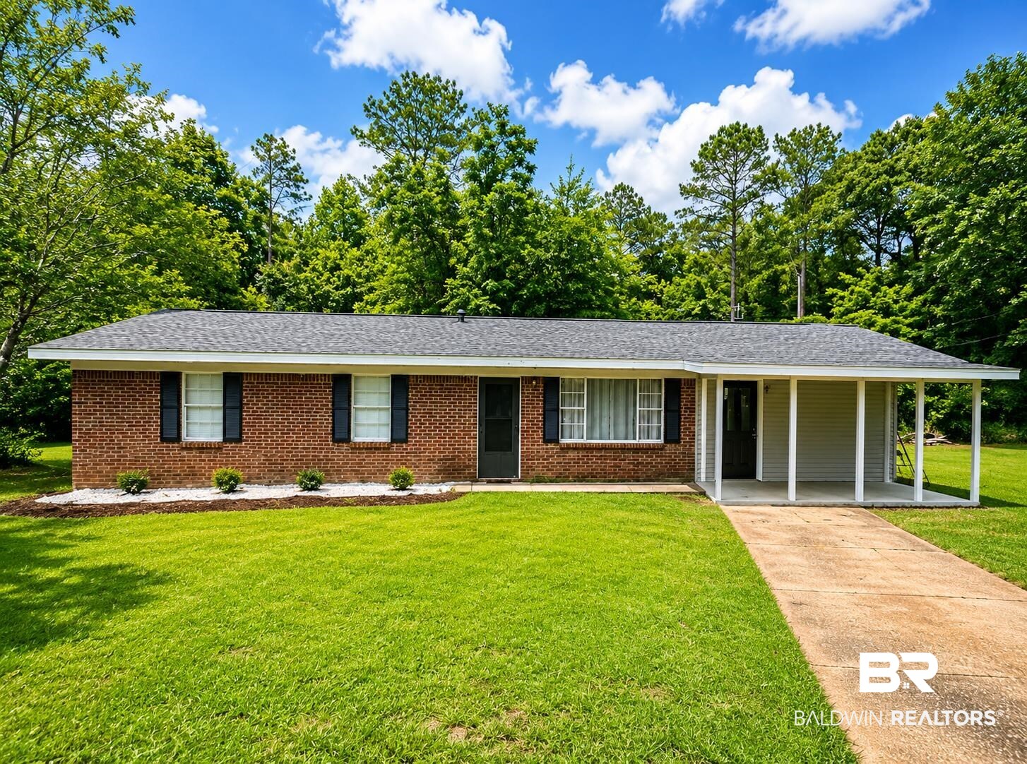 226 Elizabeth Street Evergreen, AL 36401 - Photo 2 of 35 Brick exterior with a covered carport, mature landscaping, and an asphalt shingle roof