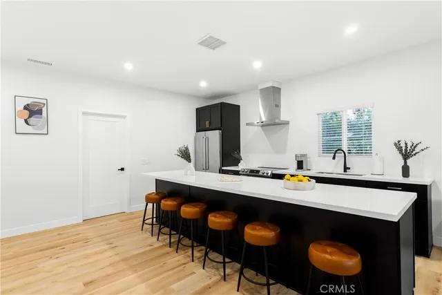 a kitchen with granite countertop a sink cabinets and wooden floor
