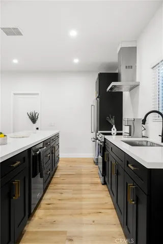 a kitchen with stainless steel appliances a sink and wooden cabinets