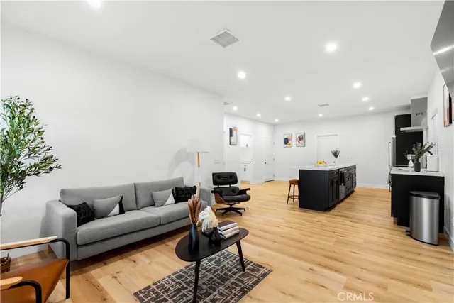 a living room with furniture a flat screen tv and a table
