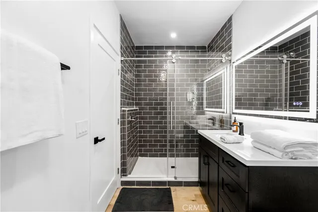a bathroom with a sink shower and a mirror