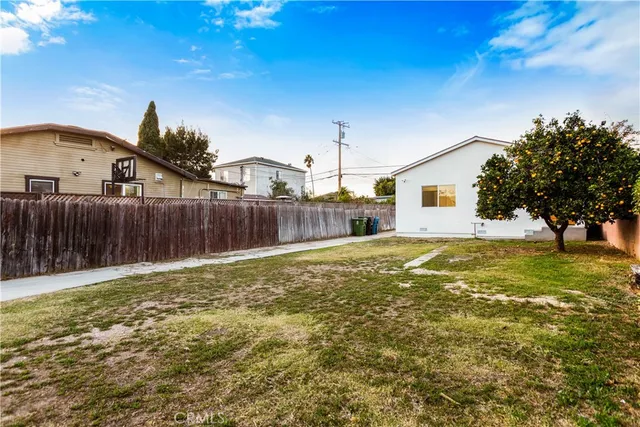 a swimming pool with yard and wooden fence