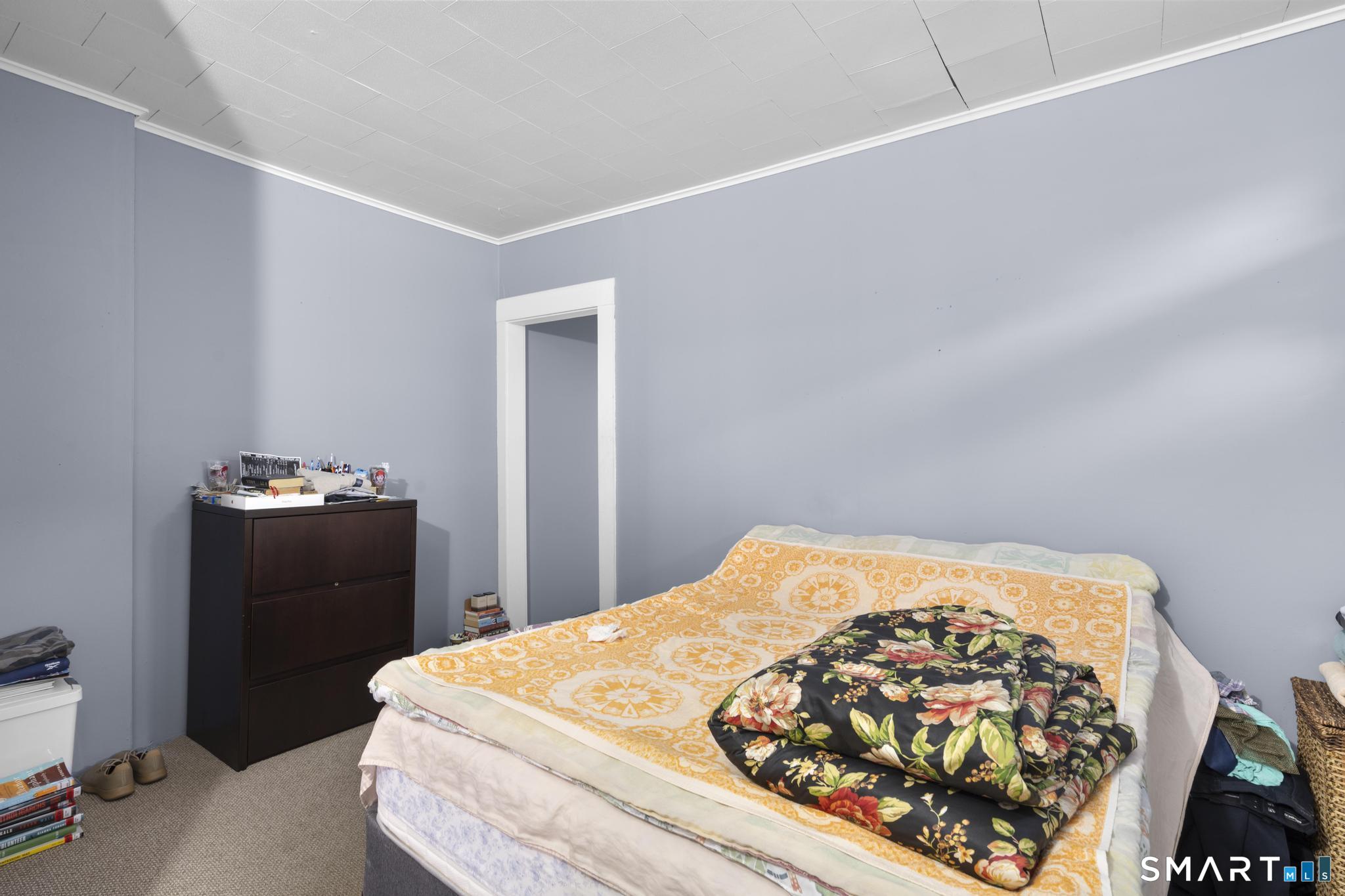 45 Cliff Street Norwich, CT 06360 - Photo 27 of 39 a bedroom with a bed and a lamp on dresser