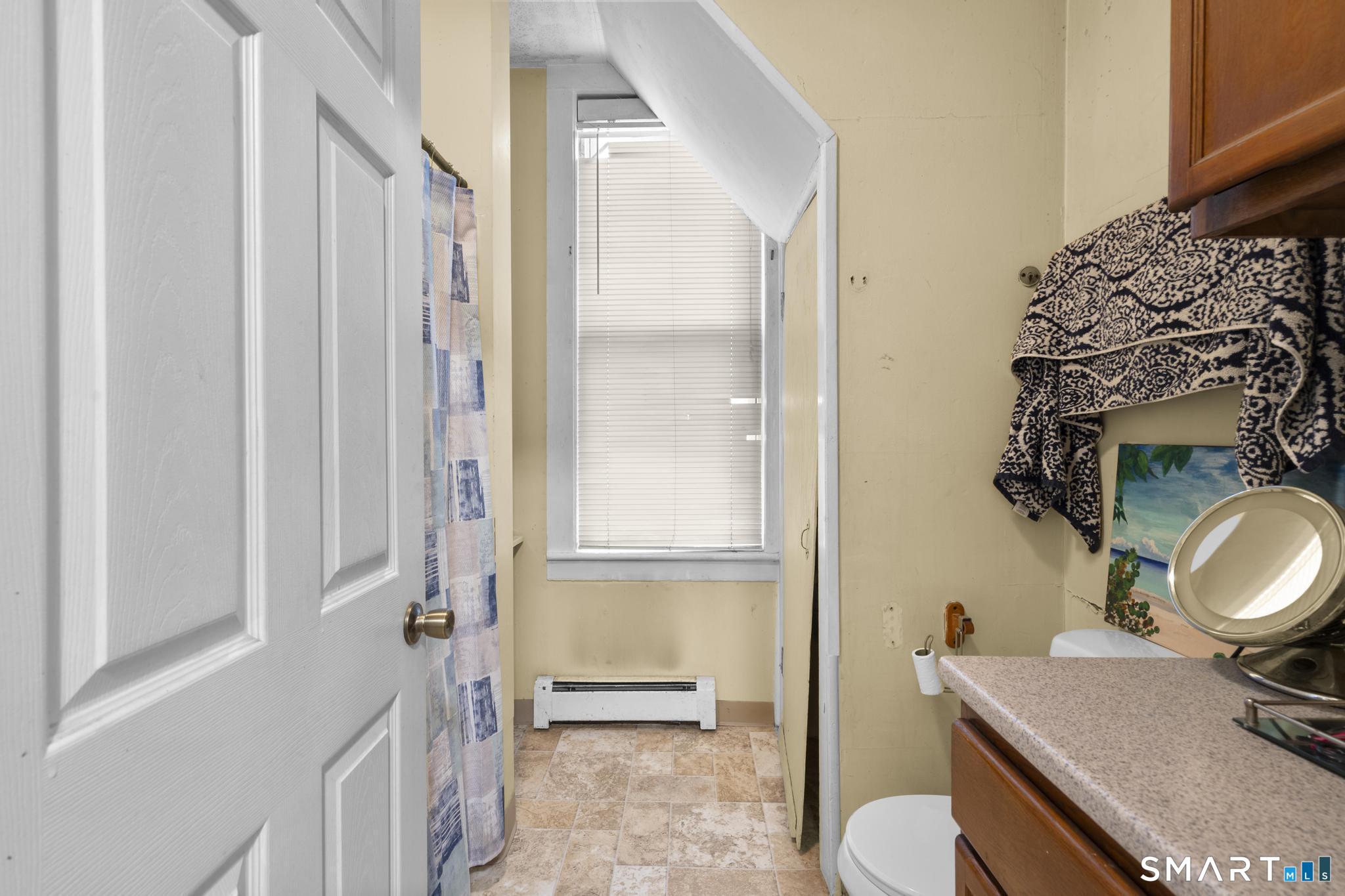 45 Cliff Street Norwich, CT 06360 - Photo 29 of 39 a bathroom with a sink a toilet and shower curtain