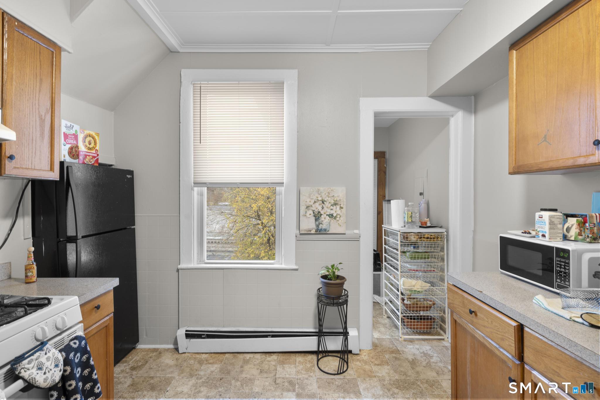 45 Cliff Street Norwich, CT 06360 - Photo 10 of 39 a kitchen with a refrigerator and a stove top oven