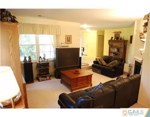 74 Woodbury Road Edison, NJ 08820 - Photo 6 of 23 a living room with furniture a flat screen tv and a floor to ceiling window