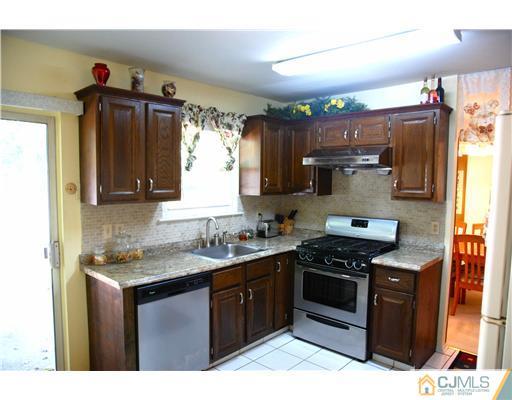 74 Woodbury Road Edison, NJ 08820 - Photo 8 of 23 a kitchen with stainless steel appliances granite countertop a sink stove and refrigerator