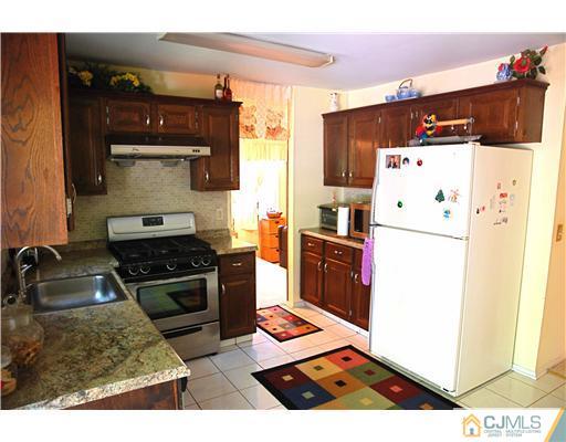 74 Woodbury Road Edison, NJ 08820 - Photo 9 of 23 a kitchen with stainless steel appliances granite countertop a refrigerator stove and sink
