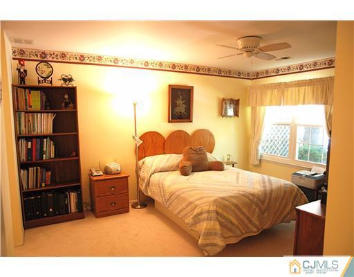 74 Woodbury Road Edison, NJ 08820 - Photo 10 of 23 a bedroom with a bed and a bookshelf with wooden floor