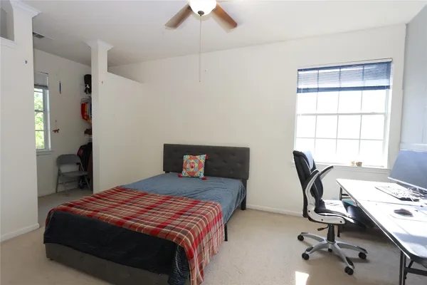 a bedroom with a bed a desk and chair