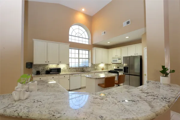 a kitchen with stainless steel appliances granite countertop a sink stove and refrigerator