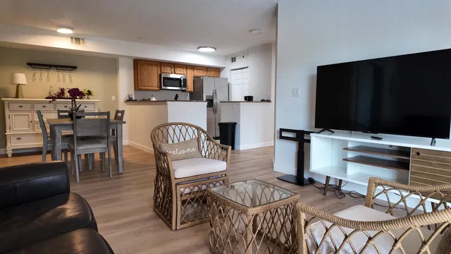 a living room with furniture a flat screen tv and kitchen view
