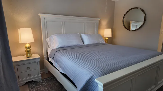 a bedroom with a bed and a mirror