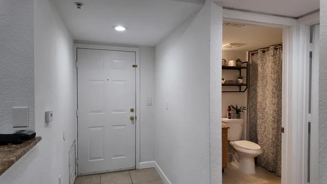 a bathroom with a granite countertop toilet and a sink